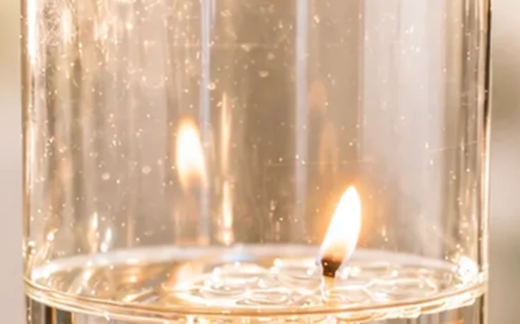 Gros plan d'une flamme posée sur la capsule, à la surface de l'eau